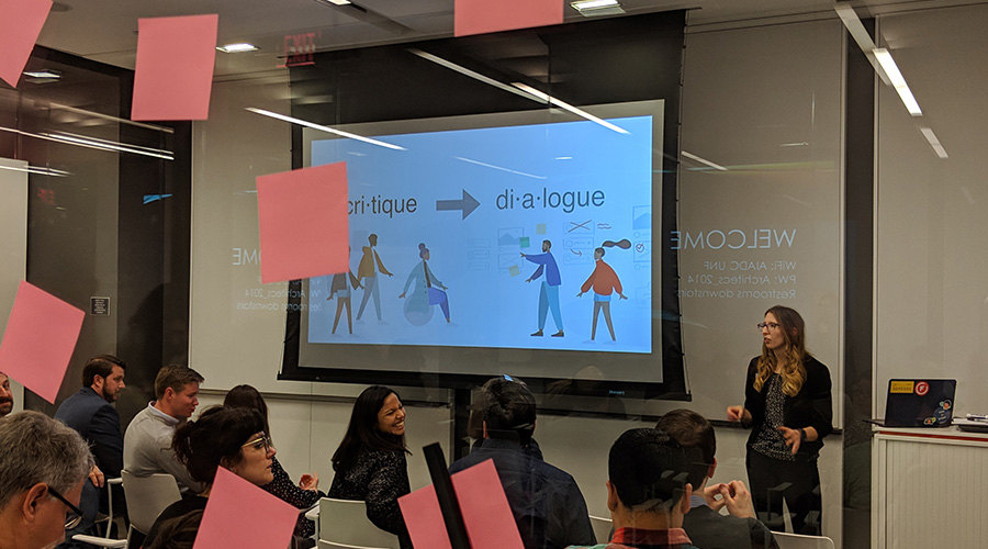 a women leading a ux camp session in front of a large screen