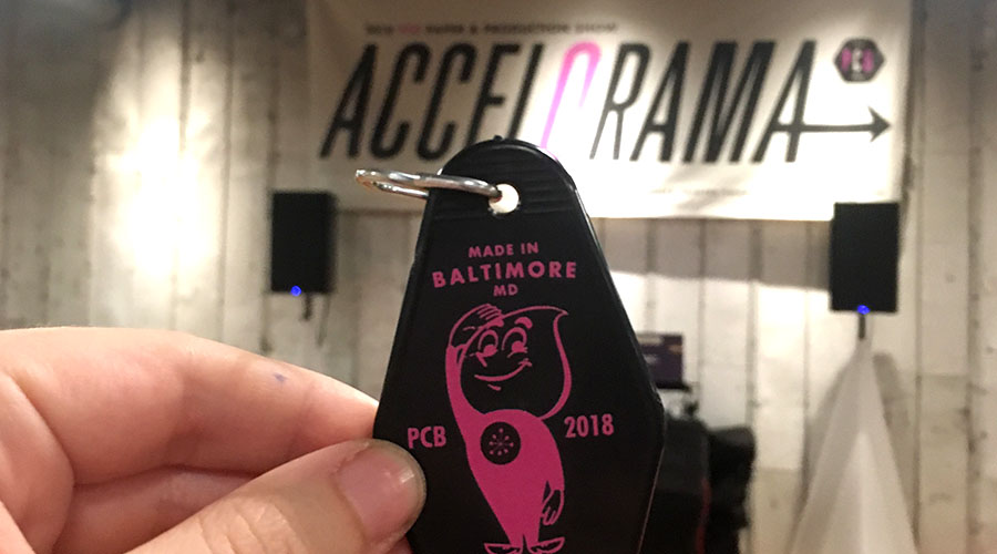 close up of a hand holding a black key chain at the PCB Production Show