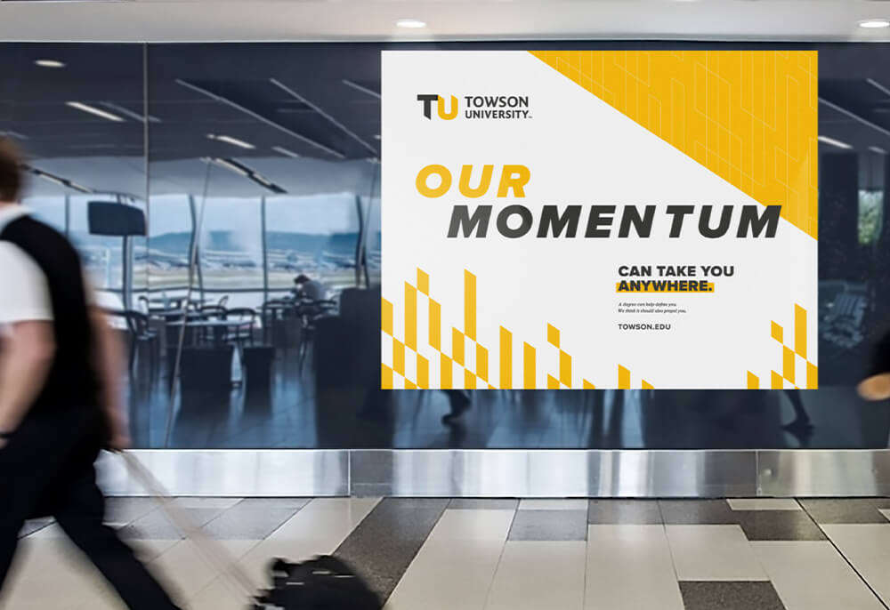 TU branded banner on campus that reads our momentum