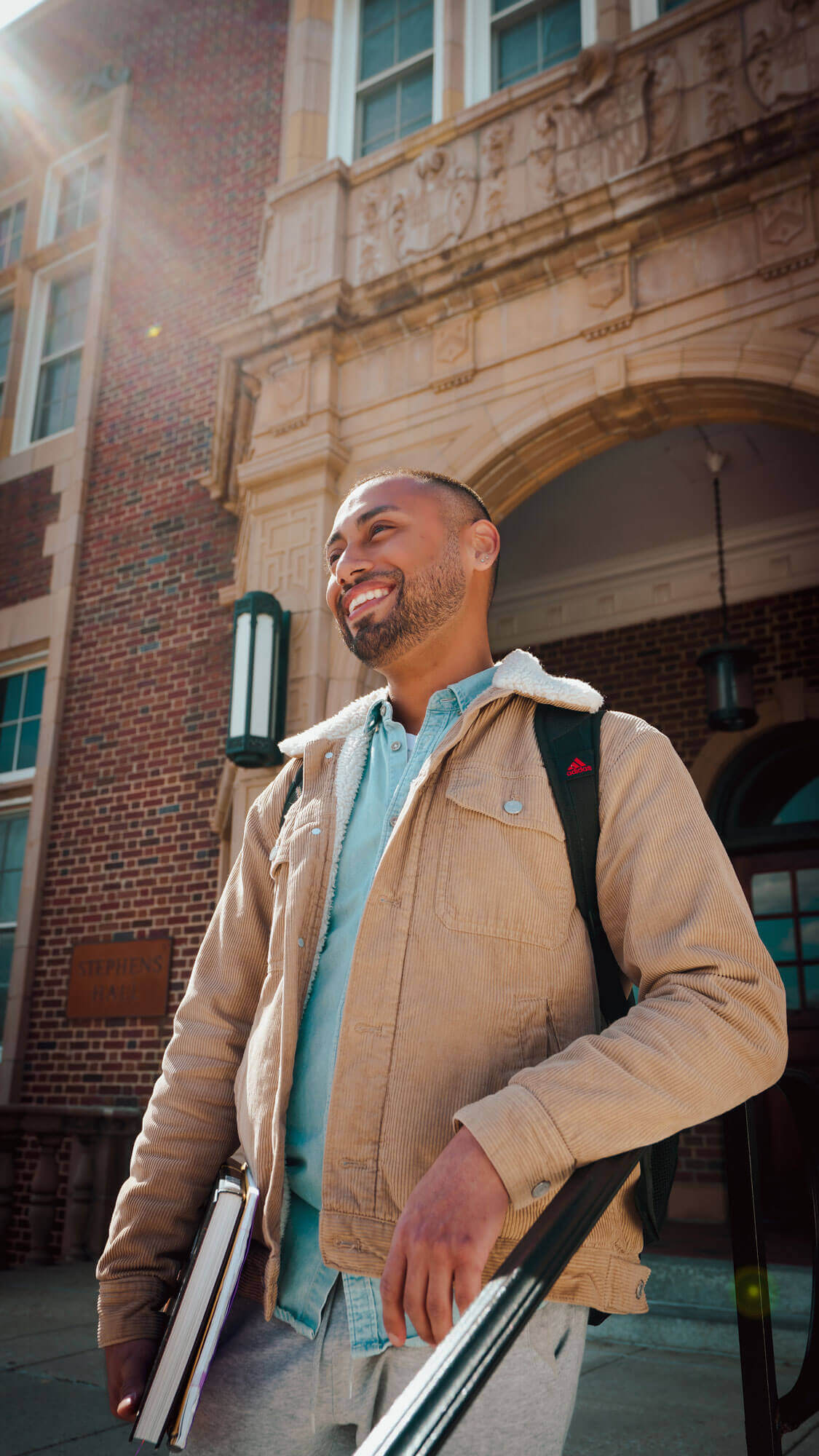 A male student standing outside of a university building.