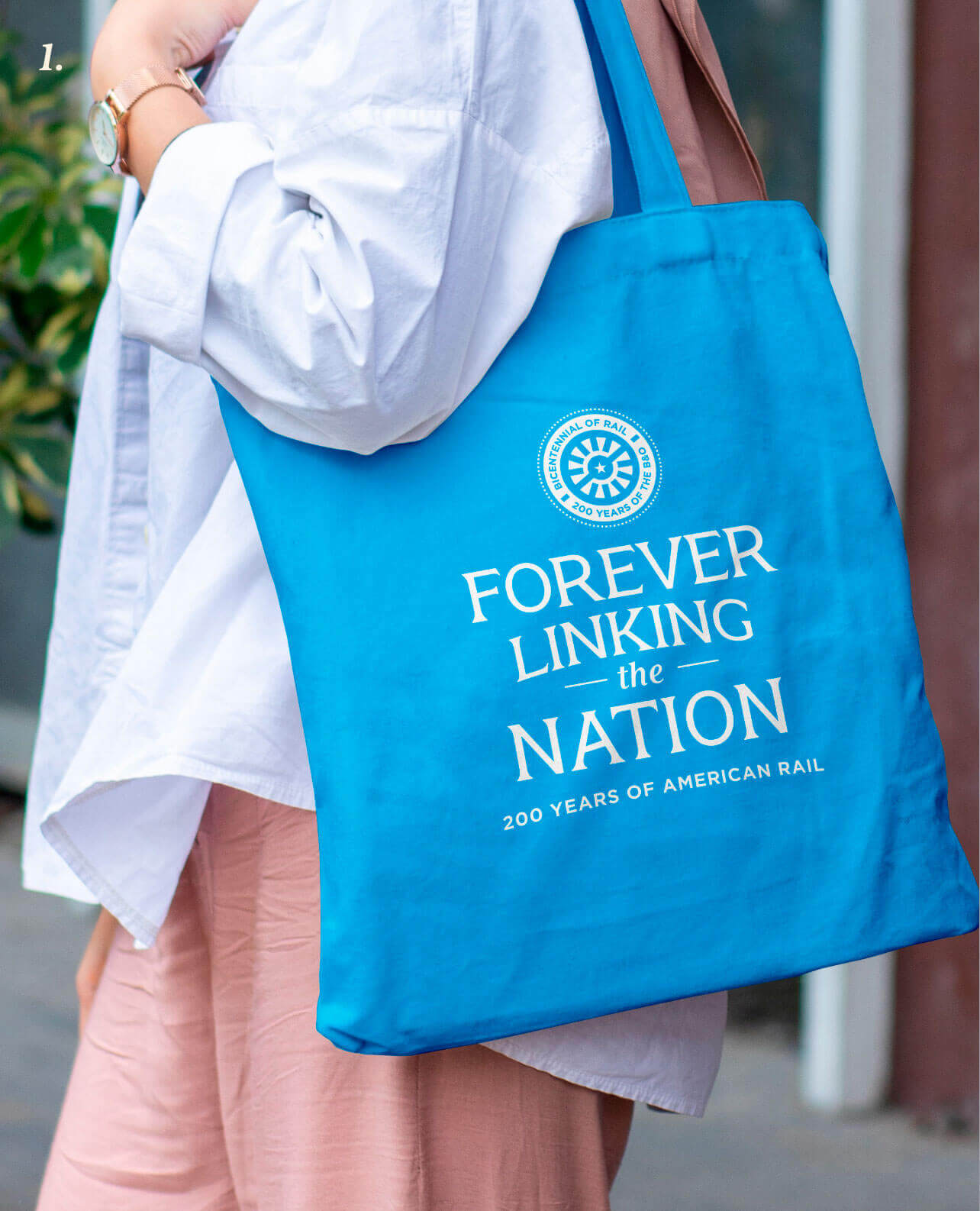 A mocked-up image of a tote bag featuring the campaign logo and tagline, reading “forever lining the nation—200 years of American rail.”