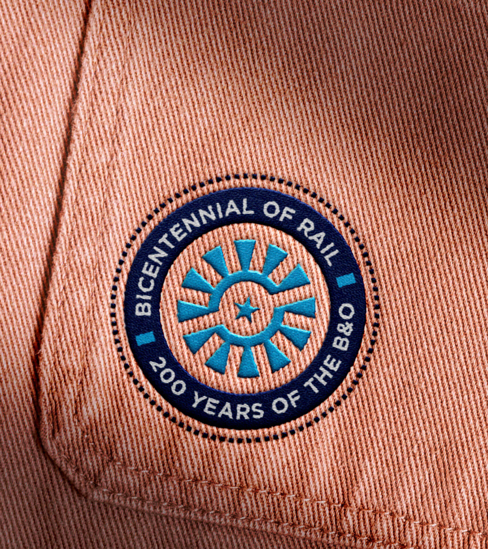 A mocked-up image of the campaign logo embroidered on tan denim clothing
