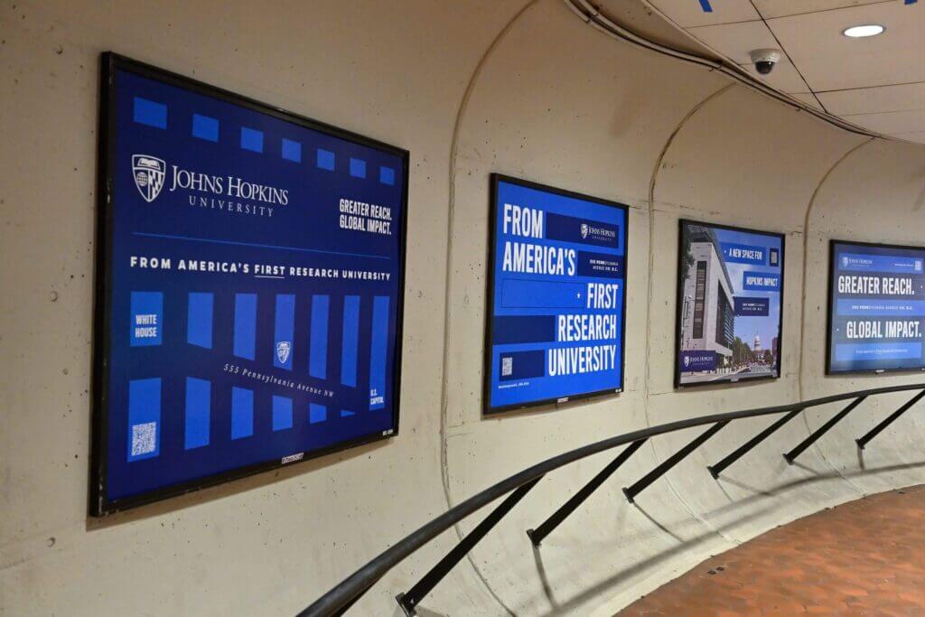 A series of poster-size advertisements in a D.C. transit hub.
