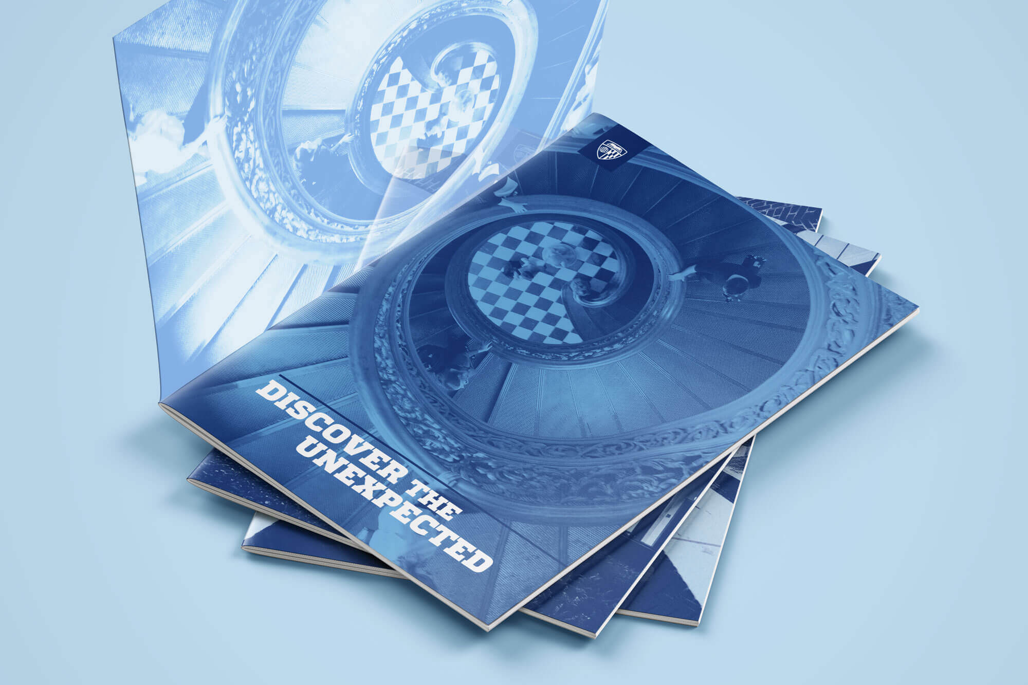 Stack of booklets titled “Discover the Unexpected.”