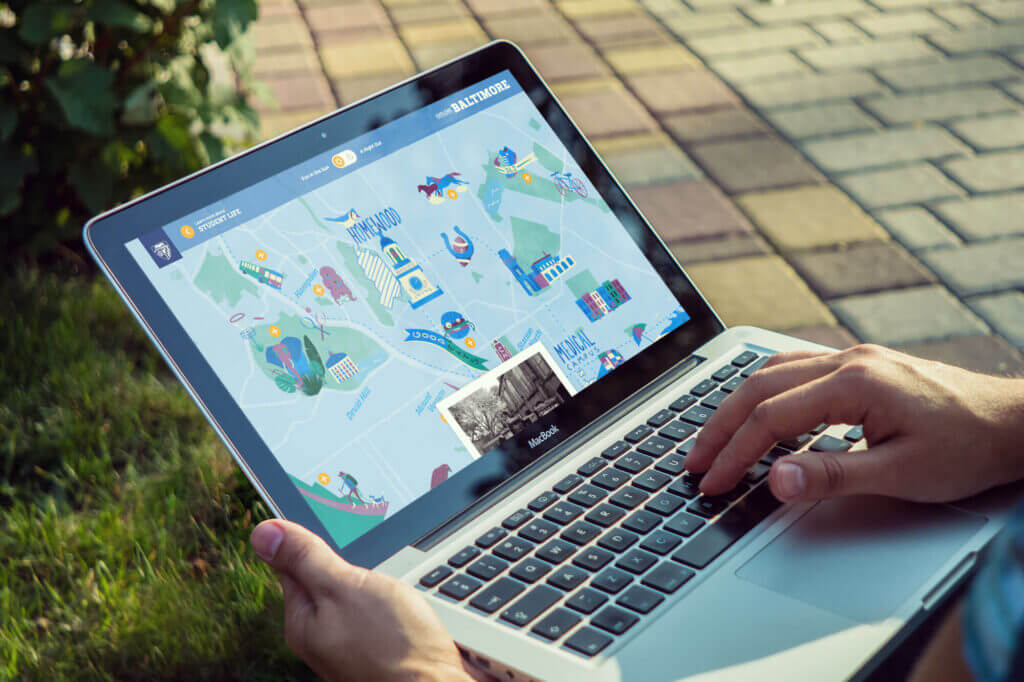 A laptop showing an illustrated map of Baltimore featuring points of interest.