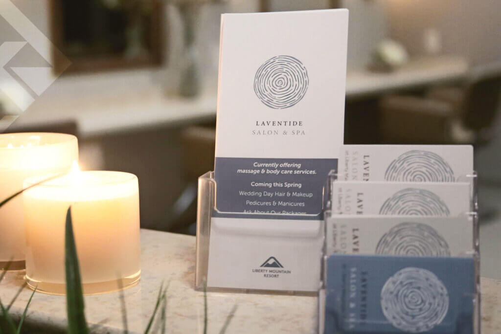 Laventide Salon & Spa brochures and business cards next to candles and plants.
