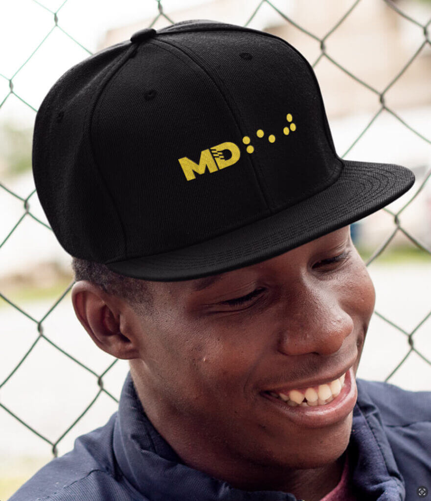 A mocked-up version of the MD TWO FIFTY logo on a black hat. TWO FIFTY is translated into braille.