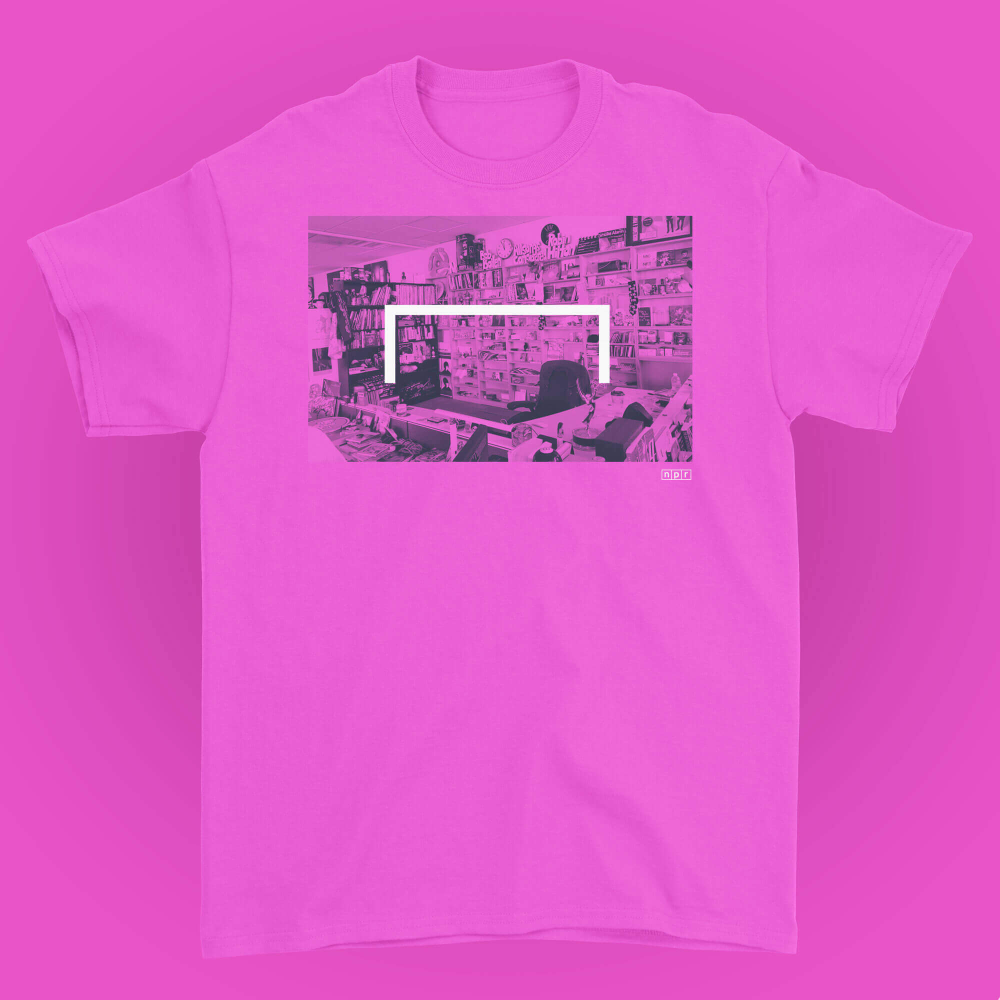 A pink t-shirt featuring a black and white photo of the Tiny Desk space on a pink background.
