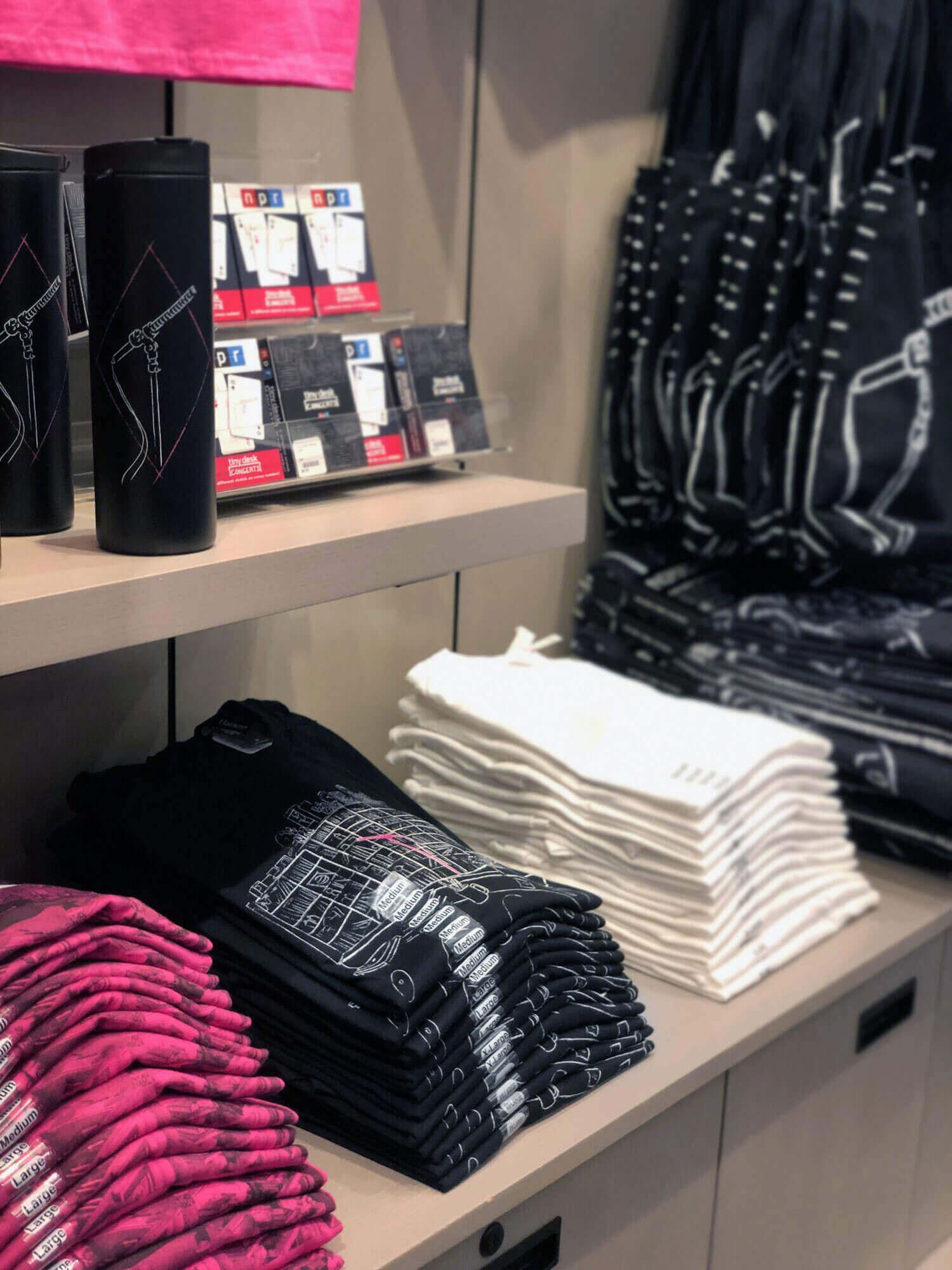 A photo of Tiny Desk merchandise folded up, on display in a gift shop.