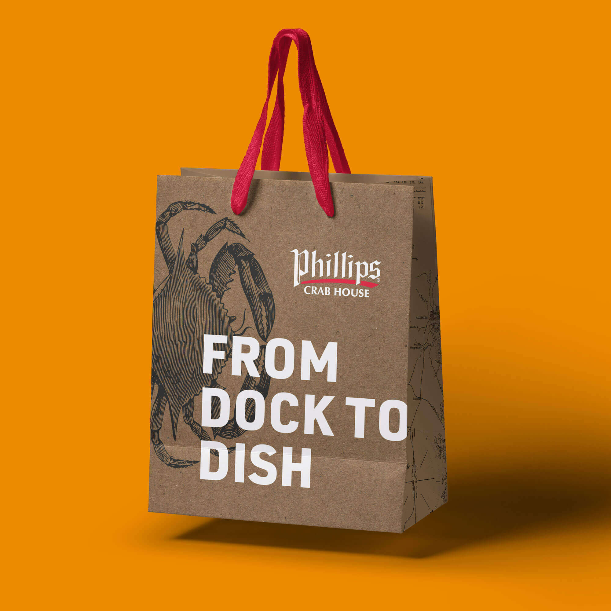 A paper bag with the Phillips crab house logo and the words “from dock to dish.”