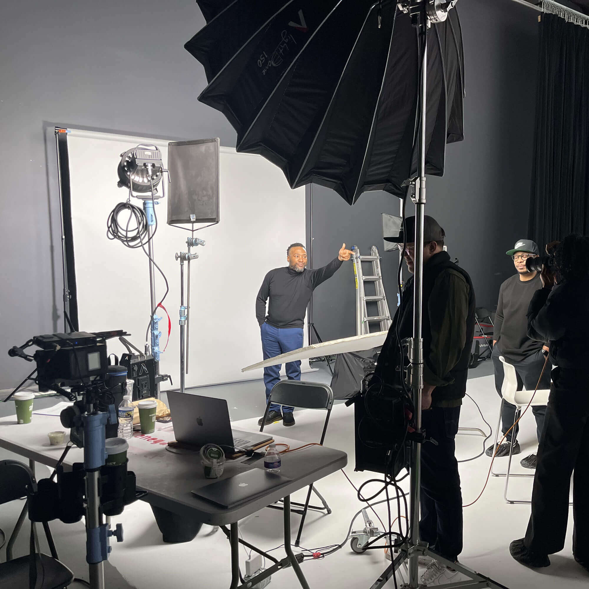 A behind-the-scenes photo from the campaign photoshoot featuring a man pointing at the camera.