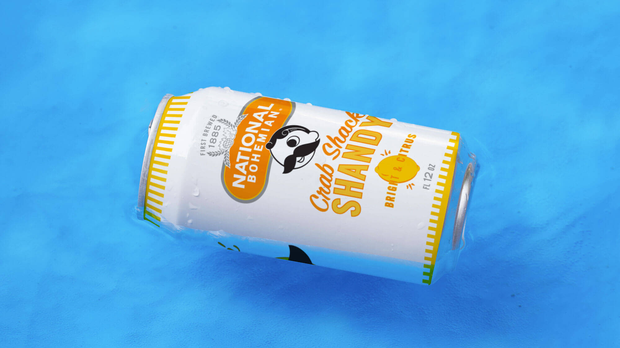 A close-up shot of a can of Crab Shack Shandy floats in a pool of water.