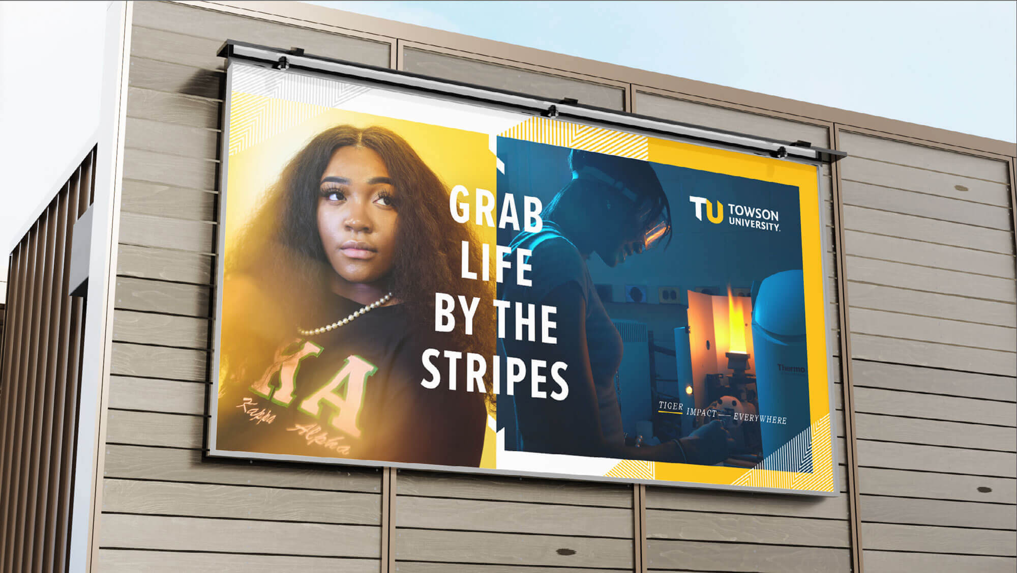A billboard on the side of a building that says, “grab life by the stripes.”